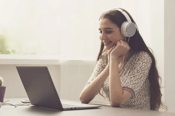 Niedliche Frau, die online Filme mit ihrem Laptop anschaut — Stockfoto