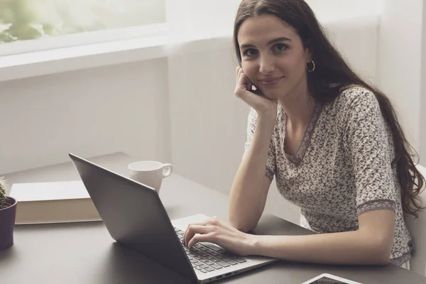 Jeune femme travaillant avec son ordinateur portable à la maison — Photo