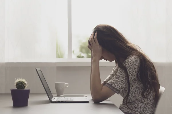 Tired stressed woman sitting at desk and connecting