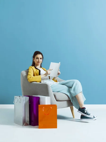 Mujer comprando y leyendo una revista de moda —  Fotos de Stock