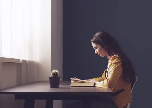 Young woman reading a book at home — Stock Photo, Image