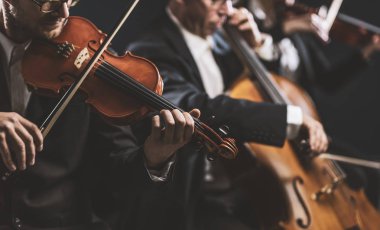 Senfonik yaylı çalgılar orkestrası sahnede performans sergiliyor