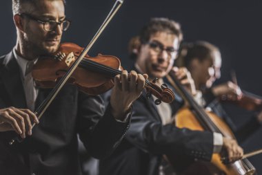 Senfonik yaylı çalgılar orkestrası sahnede performans sergiliyor