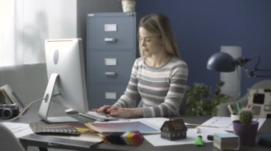 Ofis masasında çalışan genç yaratıcı tasarımcı