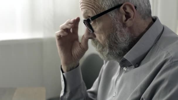 Starszy człowiek pracujący z komputerem i uczucie zmęczenia — Wideo stockowe