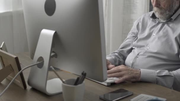 Homme âgé assis au bureau et ayant une douleur au cou — Video