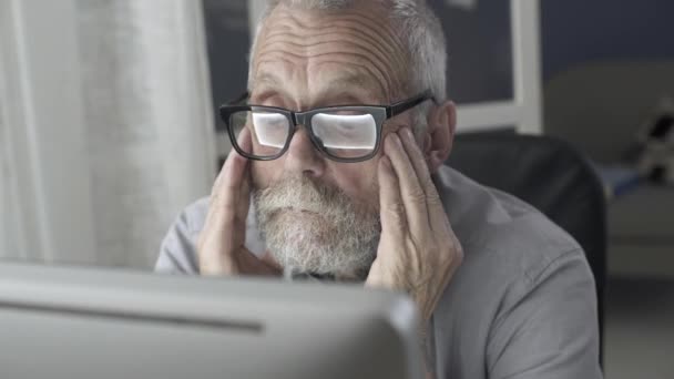 Älterer Mann arbeitet mit Computer und fühlt sich müde — Stockvideo