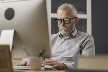 Evde bilgisayarı ile bağlanan kıdemli adam