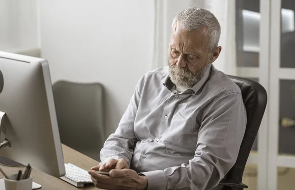 Hombre mayor usando su teléfono inteligente y conectar —  Fotos de Stock