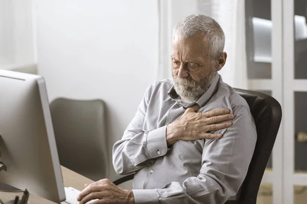 Занепокоєний старший чоловік має серцевий напад — стокове фото