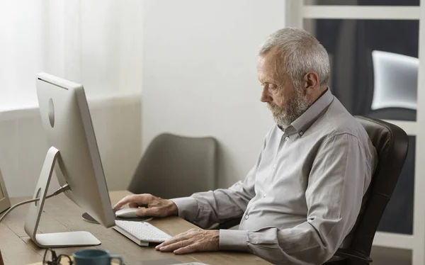 Hombre mayor usando su computadora en casa —  Fotos de Stock