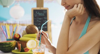 Plajda kokteyl içen çekici güzel kadın