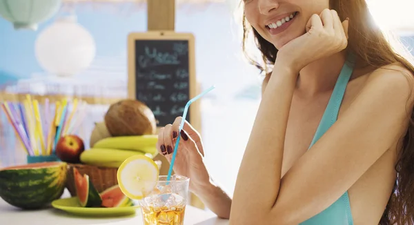 Aantrekkelijke mooie vrouw met een cocktail op het strand — Stockfoto