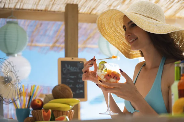 Mujer feliz en la playa comiendo una ensalada de frutas —  Fotos de Stock