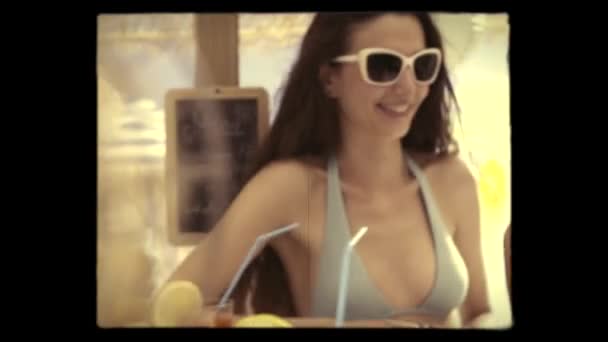 Glückliche Mädchen mit einem Drink an der Strandbar Vintage-Video — Stockvideo