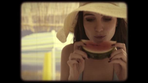 ビーチでスイカを食べる女性の8mmヴィンテージフィルム映像 — ストック動画