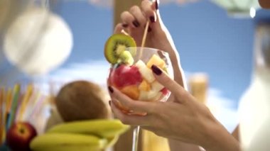 Mutlu kadın plajda lezzetli bir meyve salatası yemek