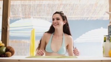 Plajda meyve salatası olan genç mutlu kadın