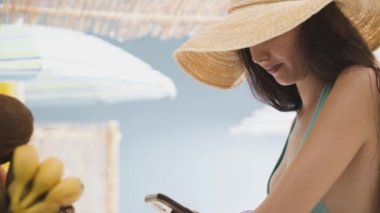 Güzel genç kadın plajda akıllı telefonu ile sohbet