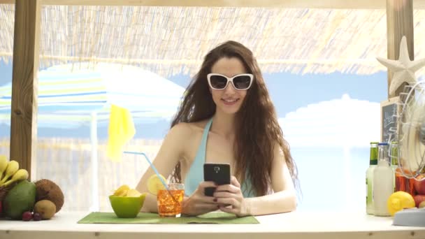 Красивая молодая женщина делает селфи на пляже — стоковое видео