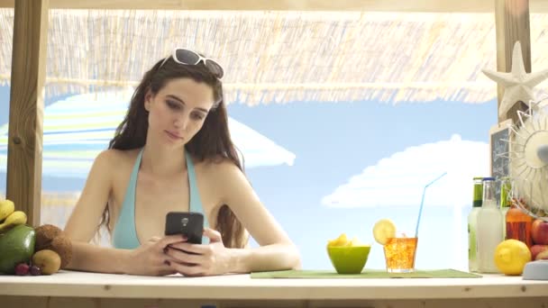美丽的年轻女子与她的智能手机在沙滩上聊天 — 图库视频影像