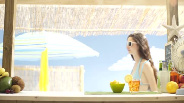 Menina bonita na praia tomando uma bebida no bar — Vídeo de Stock