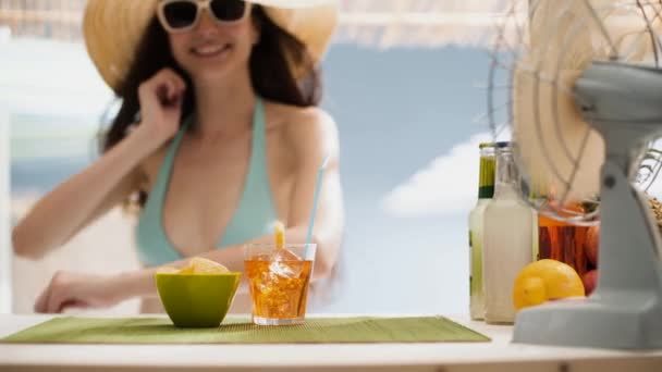 Mooi meisje met een drankje aan de strandbar kiosk — Stockvideo