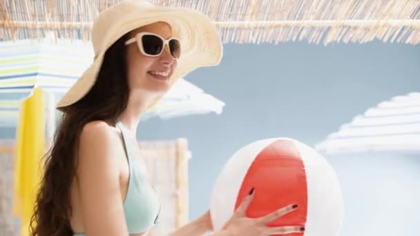 Chica alegre en la playa jugando con una pelota inflable — Vídeos de Stock