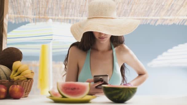 Hermosa mujer joven charlando con su teléfono en la playa — Vídeos de Stock