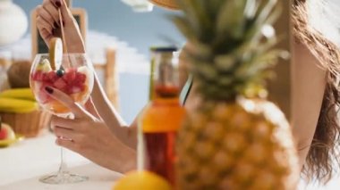 Sahilde meyve salatası yiyen gülümseyen genç kadın