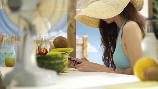 Junge Frau plaudert am Strand mit ihrem Smartphone — Stockvideo