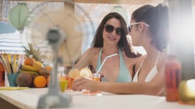 Mutlu kızlar plajda bir içki ve sohbet