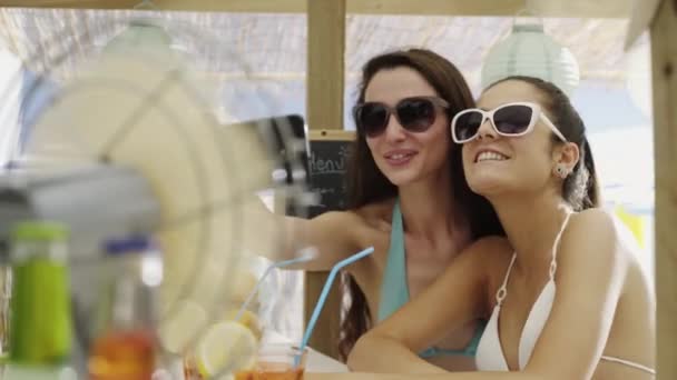 Filles heureuses buvant ensemble et prenant selfies à la plage — Video