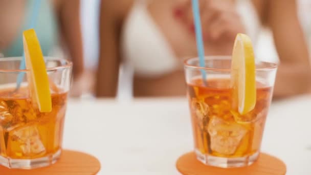 Молодые женщины пьют вместе на пляже — стоковое видео