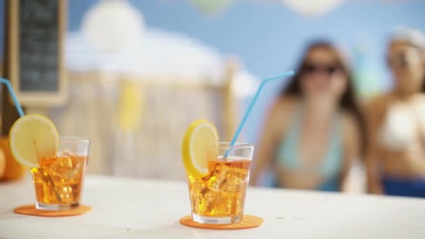 Jonge vrouwen die samen drinken op het strand — Stockvideo