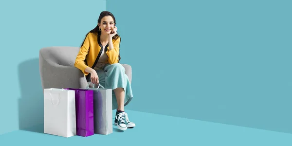 Lycklig kvinna sitter på en fåtölj efter shopping — Stockfoto