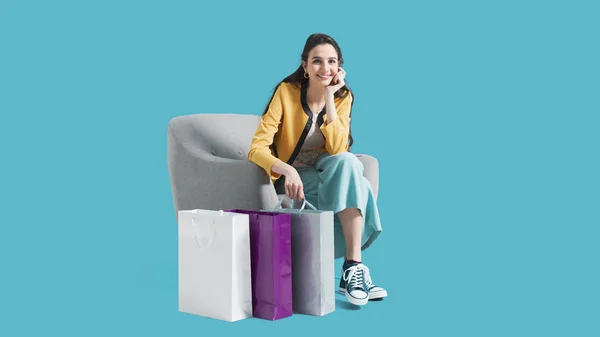 Mujer feliz sentada en un sillón después de comprar — Foto de Stock