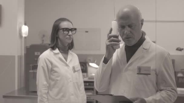 Profesor recibiendo una llamada telefónica en el laboratorio — Vídeo de stock