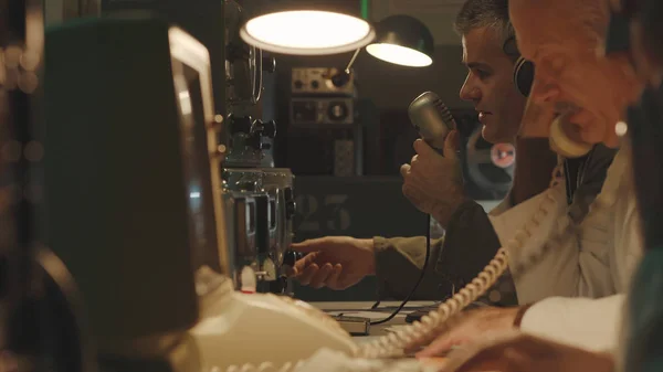 Wetenschappers die in een vintage controlekamer werken — Stockfoto