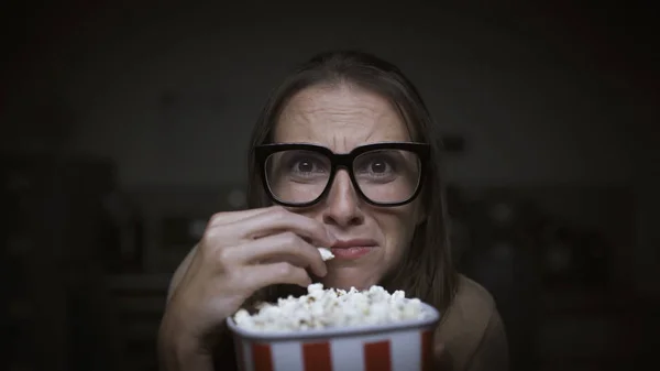 Donna che guarda un film horror e mangia popcorn — Foto Stock