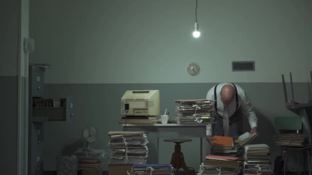 Неорганизованный бизнесмен ищет файлы в своем офисе — стоковое видео