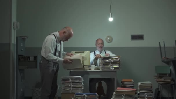 Многозадачный офисный работник ищет файлы в своем офисе — стоковое видео