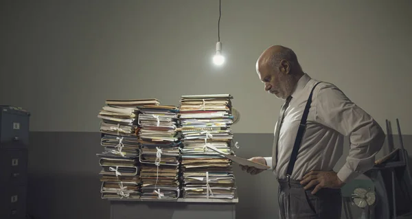 Geschäftsmann prüft Akten und stapelweise Papiere — Stockfoto