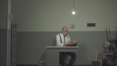 Küçük ofisinde sıkılmış bir işadamı.