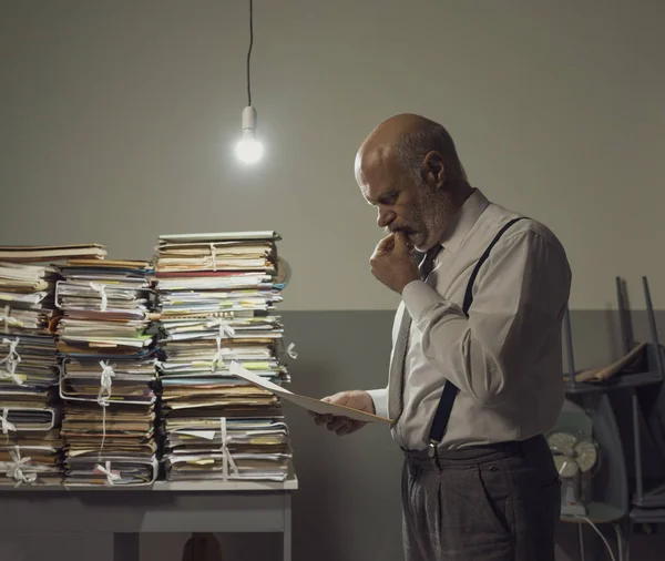 Empresario revisando archivos y montones de papeleo — Foto de Stock