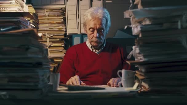 Старший бизнесмен читает бумаги с увеличителем — стоковое видео