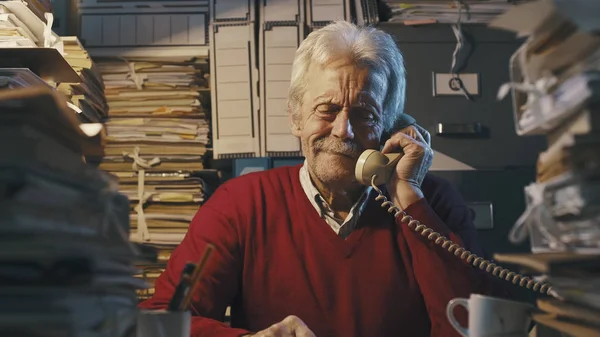 Uomo d'affari anziano che risponde alle telefonate in ufficio — Foto Stock