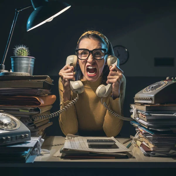 Stressed secretary shouting at the customers on the phone — ストック写真