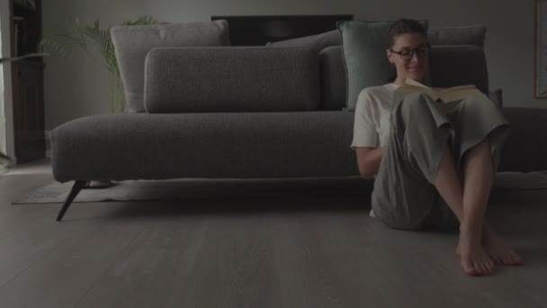 Vrouw ontspannen thuis en het lezen van een boek — Stockvideo