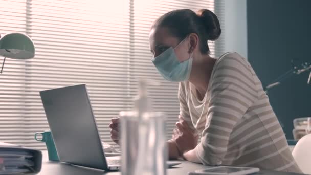 Donna d'affari con maschera facciale che fa una videochiamata in ufficio — Video Stock